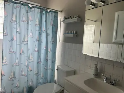 a bathroom with a shower curtain with sailboats on it at Minutes from Downtown Shopping and Dining Close to Cedar Point in Vermilion