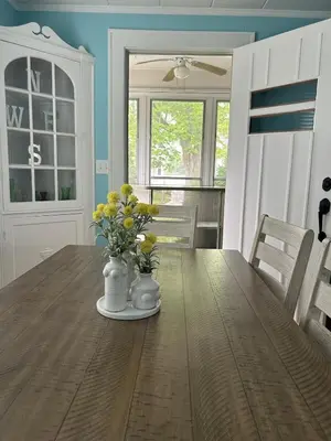 a dining room with a wooden table with flowers on it at Minutes from Downtown Shopping and Dining Close to Cedar Point in Vermilion