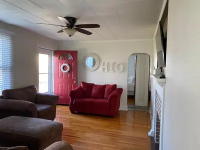 a living room with a red couch and a red door at Minutes from Downtown Shopping and Dining Close to Cedar Point in Vermilion