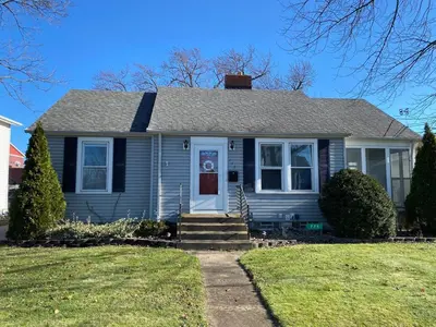 a blue house with a white door and a yard at Minutes from Downtown Shopping and Dining Close to Cedar Point in Vermilion
