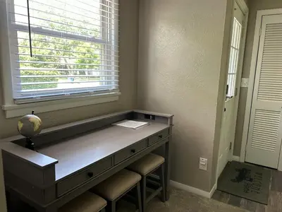 a desk in a room with a window and stools at Charming House, just a short walk to downtown in Vermilion