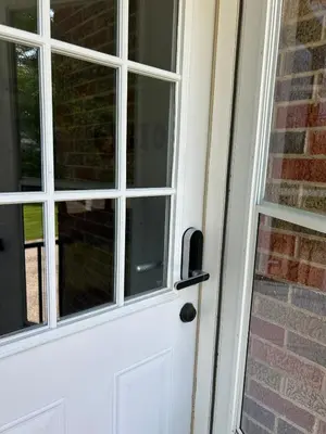 a white door with a window next to a brick wall at Charming House, just a short walk to downtown in Vermilion