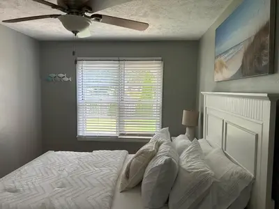 a bedroom with a white bed with a ceiling fan at Charming House, just a short walk to downtown in Vermilion