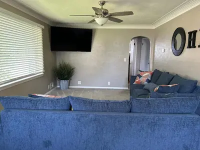 a blue couch in a living room with a ceiling fan at Charming House, just a short walk to downtown in Vermilion