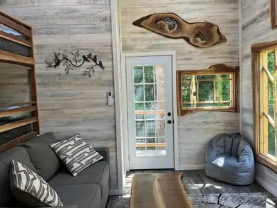a living room with a couch and a door at The Royal Roost Treehouse