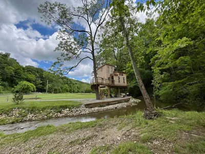 a tree house in the middle of a river at The Royal Roost Treehouse