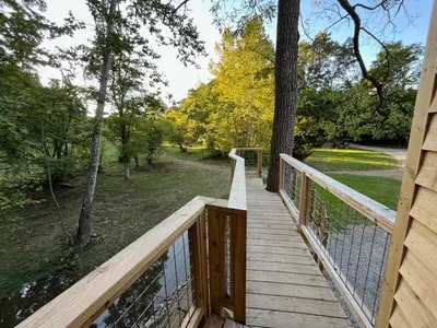 a wooden walkway with a view of a park at The Royal Roost Treehouse
