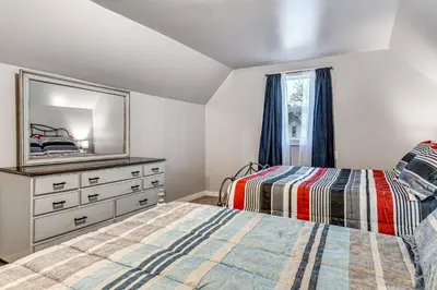 a bedroom with two beds and a dresser with a mirror at Pets Welcome! Quiet Economy Home with Spacious Yard in Economy