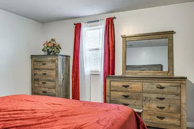 a bedroom with a bed and a dresser and a mirror at Pets Welcome! Quiet Economy Home with Spacious Yard in Economy