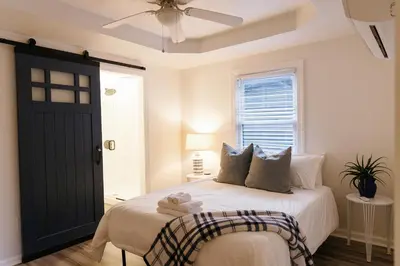 a bedroom with a bed with a black door at Big Blue - Stylish Studio in Downtown Lexington in Lexington