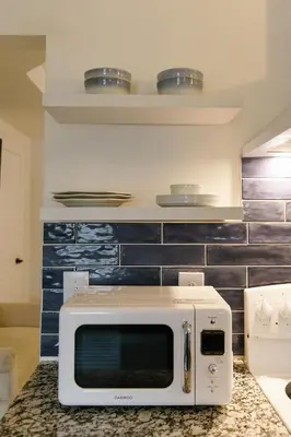a microwave sitting on a counter in a kitchen at Big Blue - Stylish Studio in Downtown Lexington in Lexington