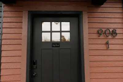 a black door of a house with the number on it at Big Blue - Stylish Studio in Downtown Lexington in Lexington