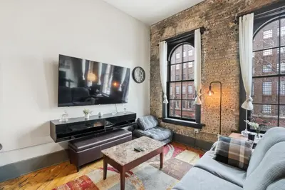 a living room with a couch and a tv at Speakeasy Attached, Walkable to Cavs, Flats, Casino in Cleveland