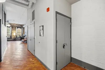a hallway with white walls and an open door at Speakeasy Attached, Walkable to Cavs, Flats, Casino in Cleveland