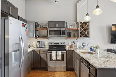 a kitchen with stainless steel appliances and granite counter tops at Speakeasy Attached, Walkable to Cavs, Flats, Casino in Cleveland