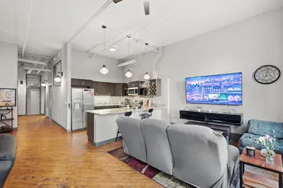 a living room with a couch and a tv at Speakeasy Attached, Walkable to Cavs, Flats, Casino in Cleveland