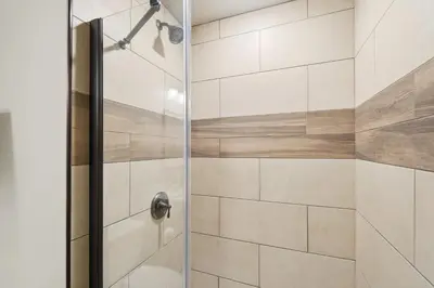 a bathroom with a shower with a glass door at Speakeasy Attached, Walkable to Cavs, Flats, Casino in Cleveland