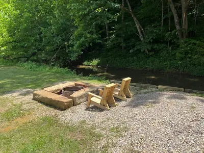 two wooden benches sitting next to a fire pit at The Owl's Perch Treehouse