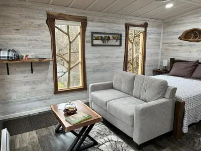 a living room with a couch and a bed at The Owl's Perch Treehouse
