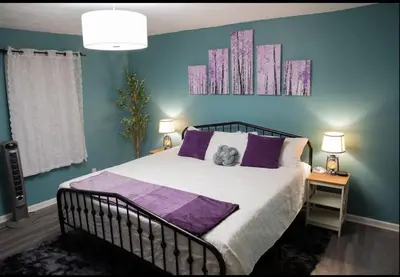 a bedroom with a large bed with purple pillows at Hot Tub Arcadia