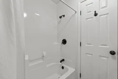 a white bathroom with a shower and a white curtain at Bourbon Trail - Loft in Downtown Lexington in Lexington