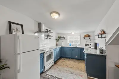 a kitchen with blue cabinets and a white refrigerator at Bourbon Trail - Loft in Downtown Lexington in Lexington