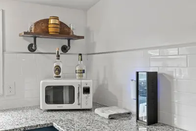 a microwave on a counter with two bottles of wine at Bourbon Trail - Loft in Downtown Lexington in Lexington