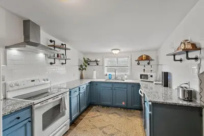 a kitchen with blue cabinets and white appliances at Bourbon Trail - Loft in Downtown Lexington in Lexington