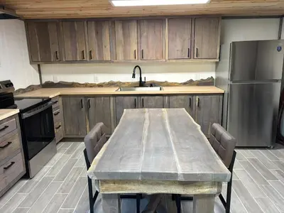 a kitchen with a table and a stainless steel refrigerator at The Conservatory at Owl Hollow in Woodsfield
