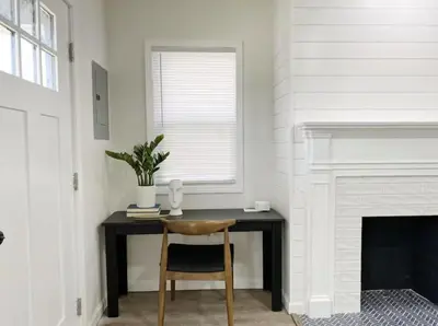a table with a chair in a room with a fireplace at Gardenia - Stylish Apartment in Downtown Lexington in Lexington