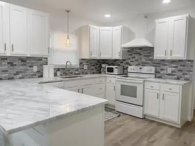 a kitchen with white cabinets and white appliances at Gardenia - Stylish Apartment in Downtown Lexington in Lexington