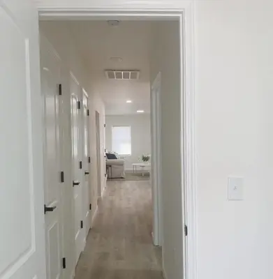 a hallway with white walls and wood floors and a room at Gardenia - Stylish Apartment in Downtown Lexington in Lexington