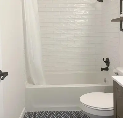a white bathroom with a toilet and a bath tub at Gardenia - Stylish Apartment in Downtown Lexington in Lexington