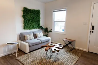 a living room with a couch and a table at Green Oasis - Studio in Downtown Lexington in Lexington