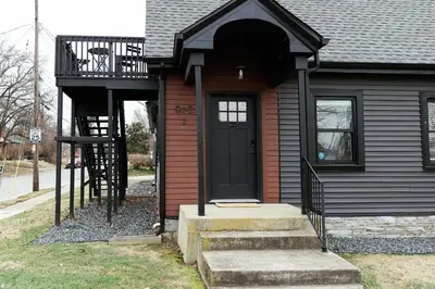 a house with a black door and a balcony at Green Oasis - Studio in Downtown Lexington in Lexington