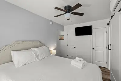 a bedroom with a white bed with a ceiling fan at Mint Julep - Studio in Downtown Lexington in Lexington