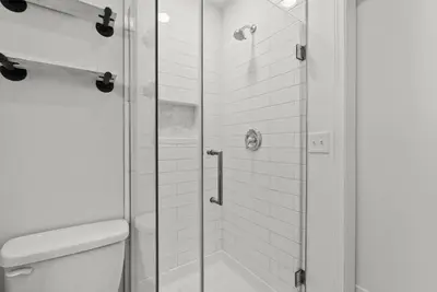 a bathroom with a toilet and a glass shower at Mint Julep - Studio in Downtown Lexington in Lexington