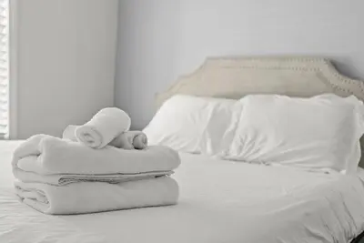 a pile of towels sitting on a bed at Mint Julep - Studio in Downtown Lexington in Lexington