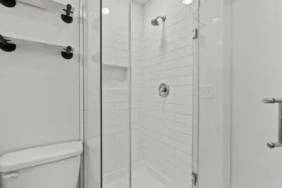 a bathroom with a toilet and a glass shower at Mint Julep - Studio in Downtown Lexington in Lexington