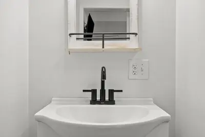 a bathroom with a sink and a mirror above it at Mint Julep - Studio in Downtown Lexington in Lexington