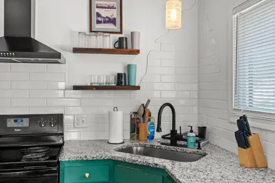 a kitchen counter with a sink and a stove at Mint Julep - Studio in Downtown Lexington in Lexington