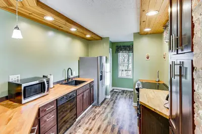 a large kitchen with wooden floors and green walls at 6 Mi to Dtwn Cincinnati Dog-Friendly Apt with Yard in Cincinnati