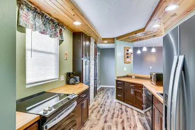 a kitchen with wooden cabinets and a stainless steel refrigerator at 6 Mi to Dtwn Cincinnati Dog-Friendly Apt with Yard in Cincinnati