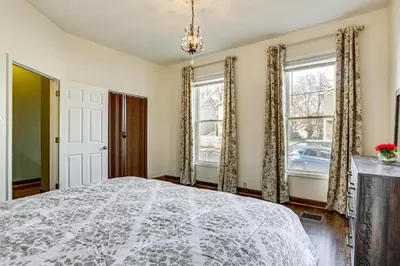 a bedroom with a large bed and two windows at 6 Mi to Dtwn Cincinnati Dog-Friendly Apt with Yard in Cincinnati