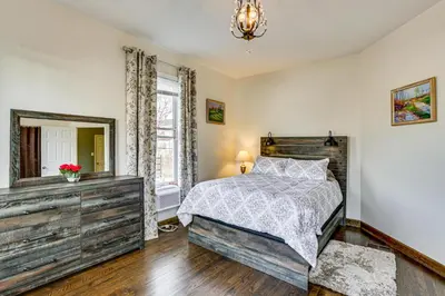 a bedroom with a bed and a dresser and a mirror at 6 Mi to Dtwn Cincinnati Dog-Friendly Apt with Yard in Cincinnati