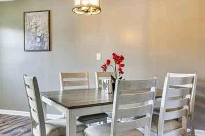 a dining room table and chairs with red flowers on it at 6 Mi to Dtwn Cincinnati Dog-Friendly Apt with Yard in Cincinnati