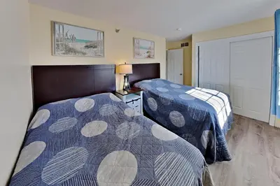 two beds in a hotel room with two bedsskirtspectspectssenalsenal at Put-in-Bay Poolview Condo #6 in Put-in-Bay