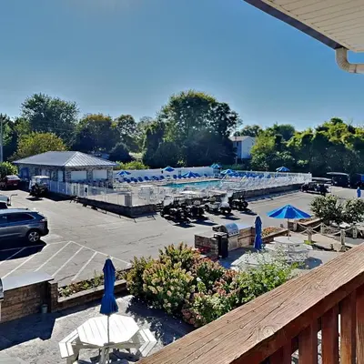 a parking lot with tables and umbrellas and a parking lot with cars at Put-in-Bay Poolview Condo #6 in Put-in-Bay