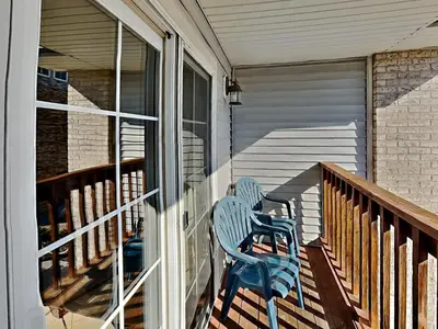 two blue chairs sitting on the porch of a house at Put-in-Bay Poolview Condo #6 in Put-in-Bay