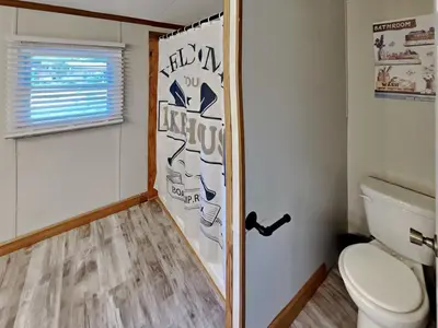 a bathroom with a toilet and a window and a door at Put-in-Bay Island Club #65 in Put-in-Bay